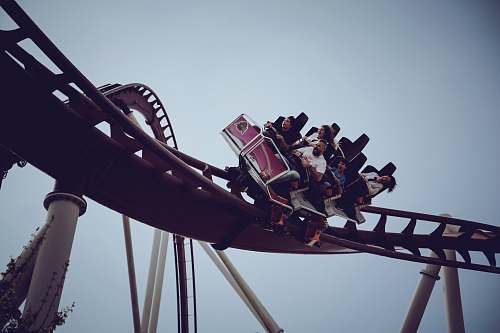 amusement park six person riding on roller coaster at daytime coaster